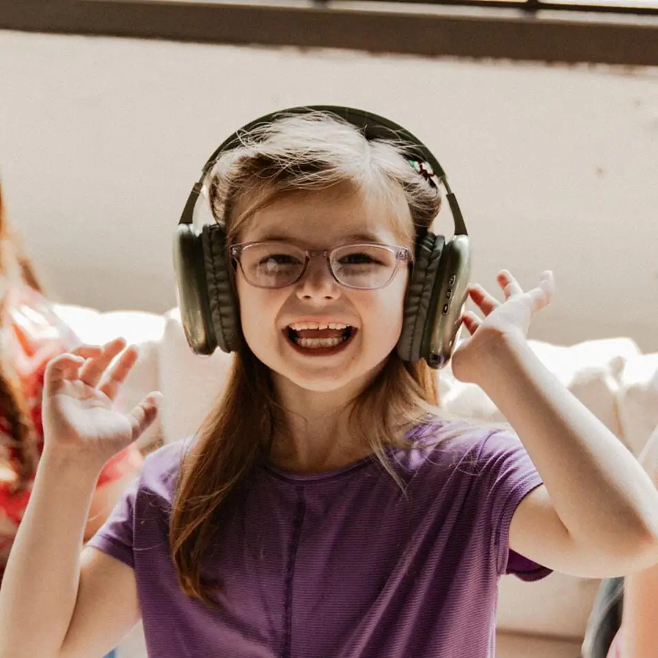 طالب يبتسم وهو يرتدي زوجاً من السماعات