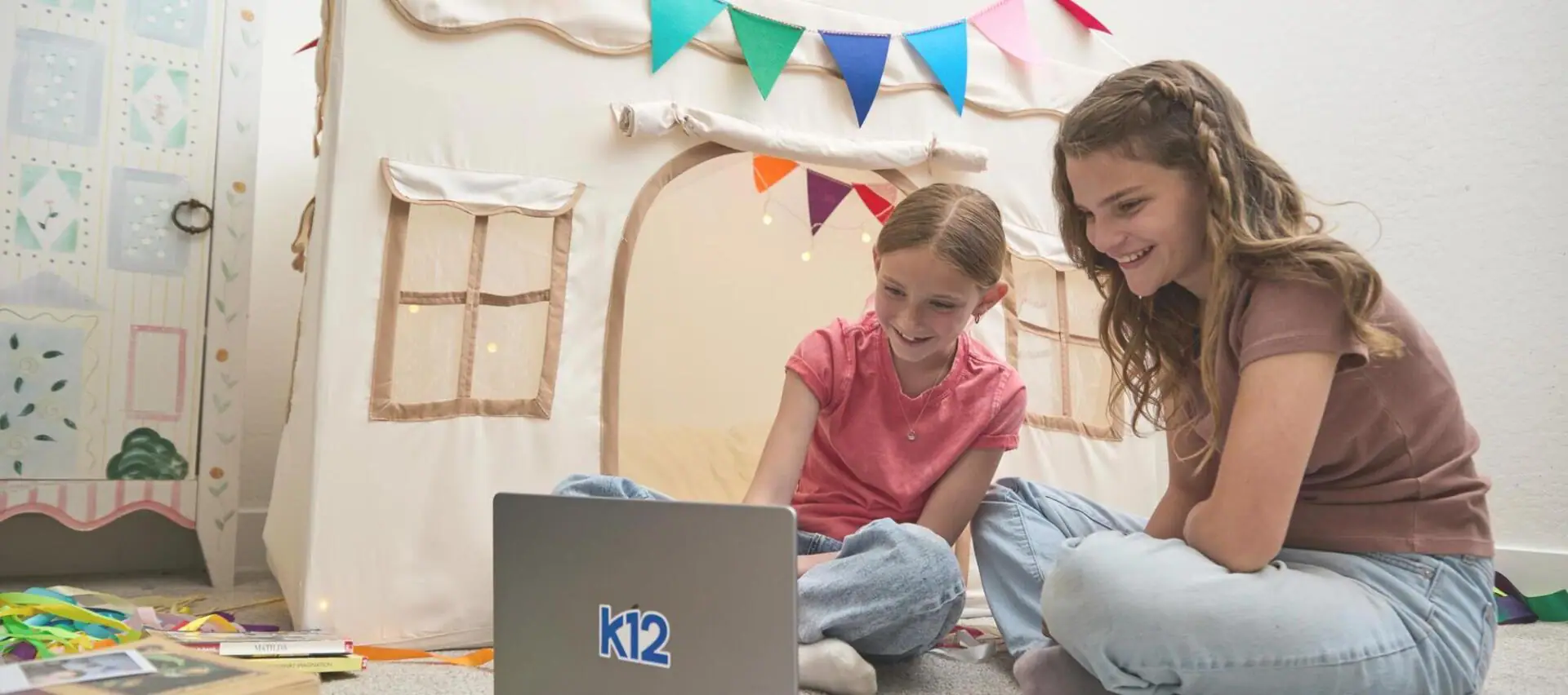 أم وابنتها تعملان معًا مع الكمبيوتر المحمول الخاص بهما في المنزل