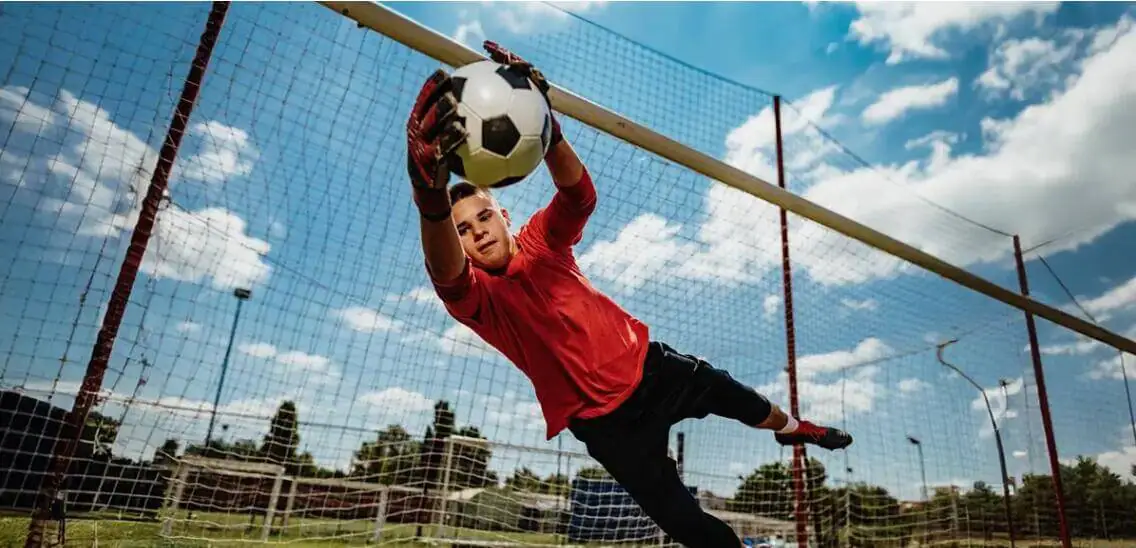 طالب يلعب كرة القدم