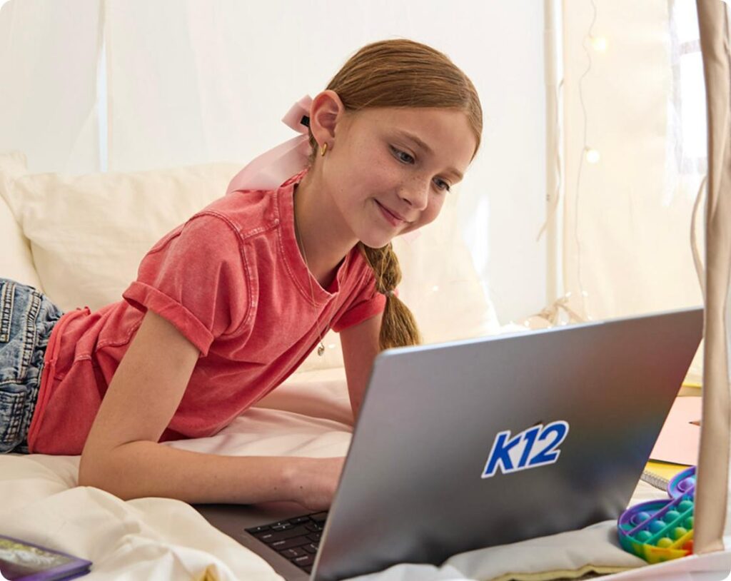 طالبة تعمل مع حاسوبها المحمول في المنزل