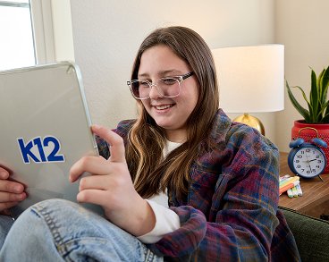 طالبة تقرأ من جهازها اللوحي